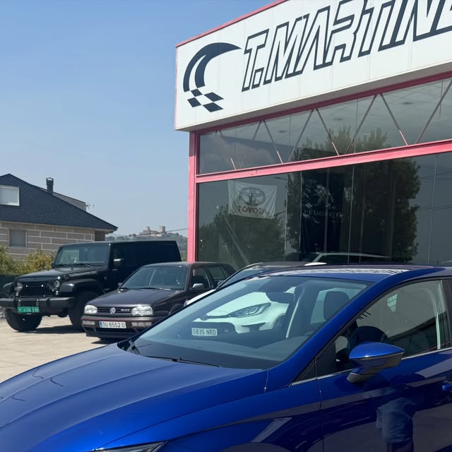 Seat Ibiza azul aparcado frente a la cristalera del concesionario