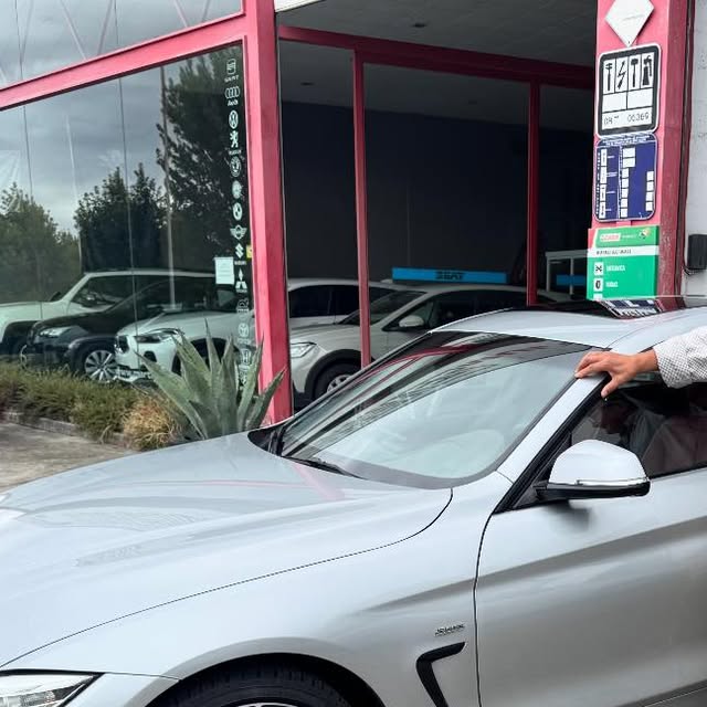 BMW Serie 4 Gran Coupé plateado frente a la entrada del concesionario